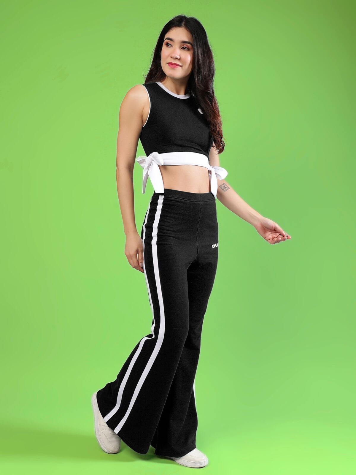 WOMENS FITTONIA COOL CO-ORD SET BLACK on a model against a green background, showcasing sporty-luxe style and comfort.