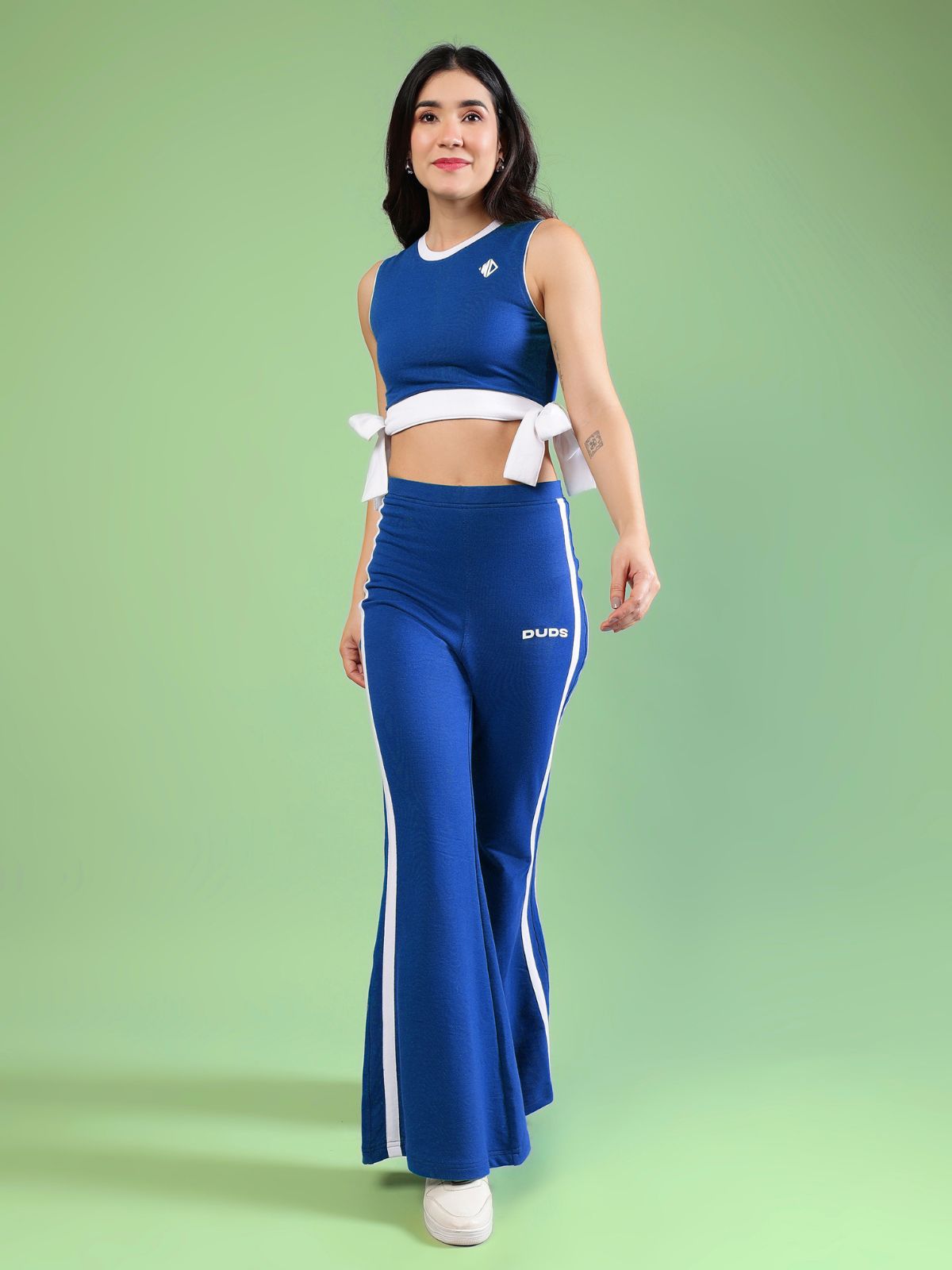WOMENS FITTONIA COOL CO-ORD SET BLUE worn by model on green background, showcasing chic sporty style.