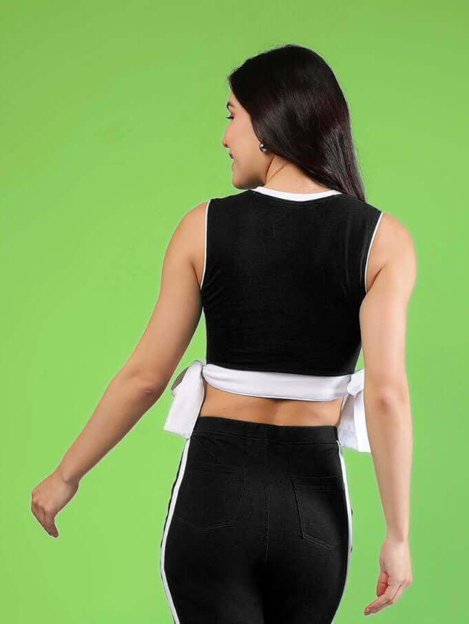 WOMENS FITTONIA COOL CROP TOP BLACK on a model, showcasing a sleek black design with a modern cut.