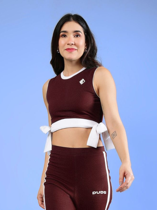 WOMENS FITTONIA COOL CROP TOP MAROON worn by a model on a blue background, showcasing the stylish design and fit.