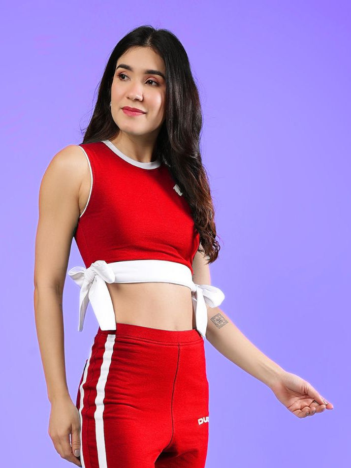 WOMENS FITTONIA COOL CROP TOP RED worn by a woman, showcasing a stylish red crop top with white accents.