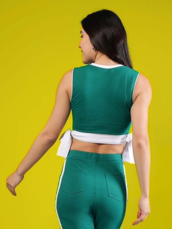 Model wearing teal green women's Fittonia cool crop top, showcasing back view against a vibrant yellow background.
