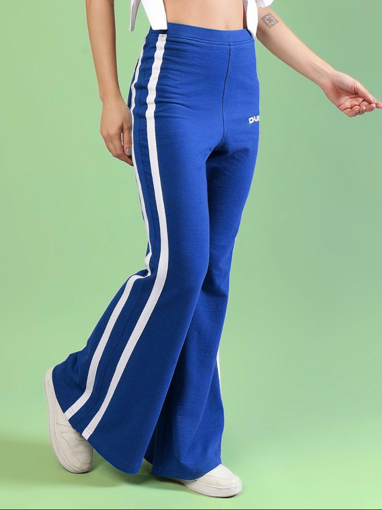 WOMENS FITTONIA COOL WIDE FLARE JOGGERS BLUE being worn by a model against a green background.