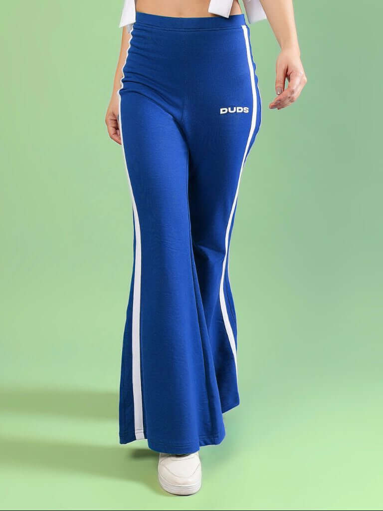 WOMENS FITTONIA COOL WIDE FLARE JOGGERS BLUE showcased by a model, featuring a stylish wide-flare design and vibrant blue color.