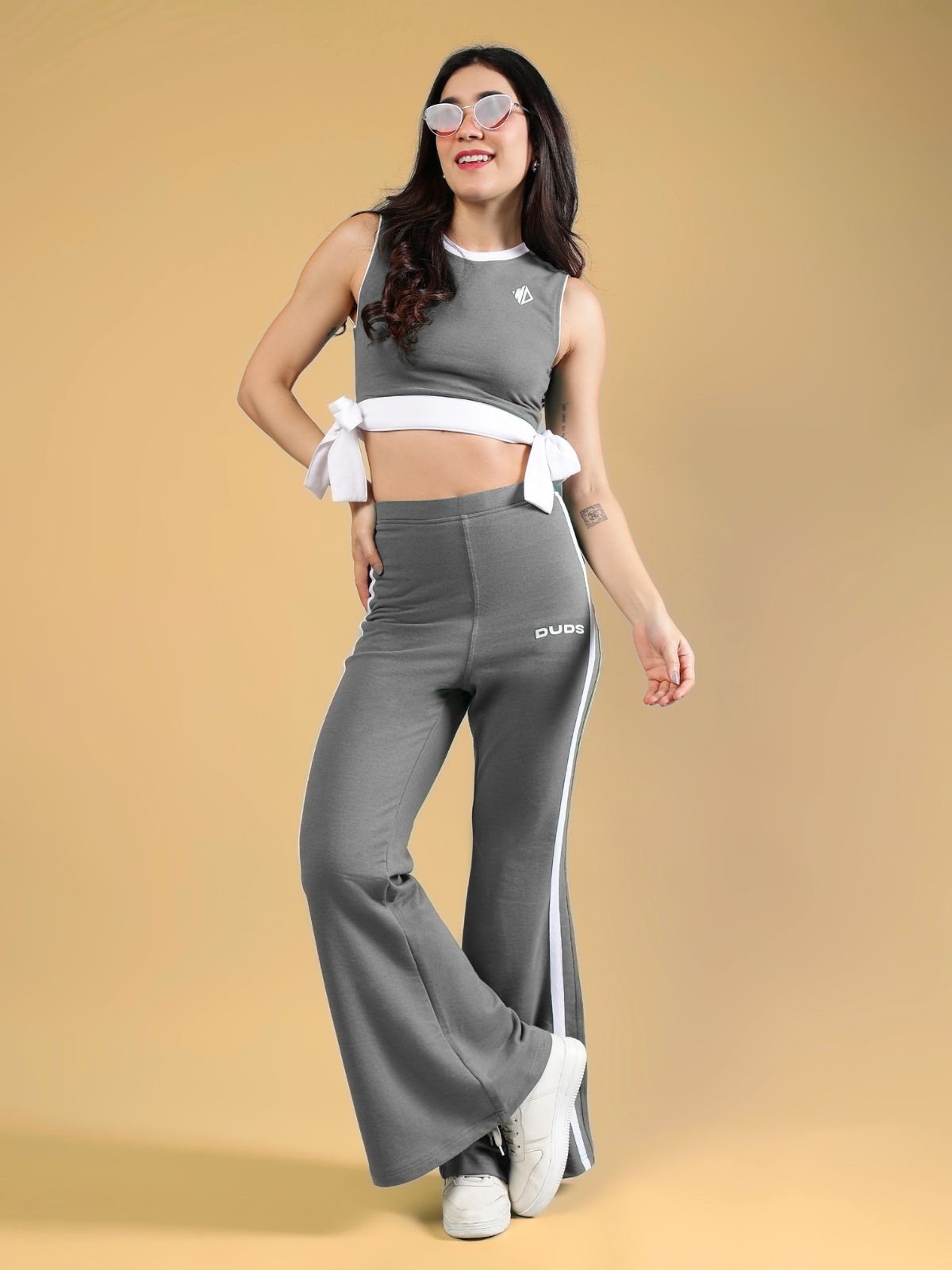 WOMENS FITTONIA COOL WIDE FLARE JOGGERS GERY in grey worn by model with sporty top and sunglasses.