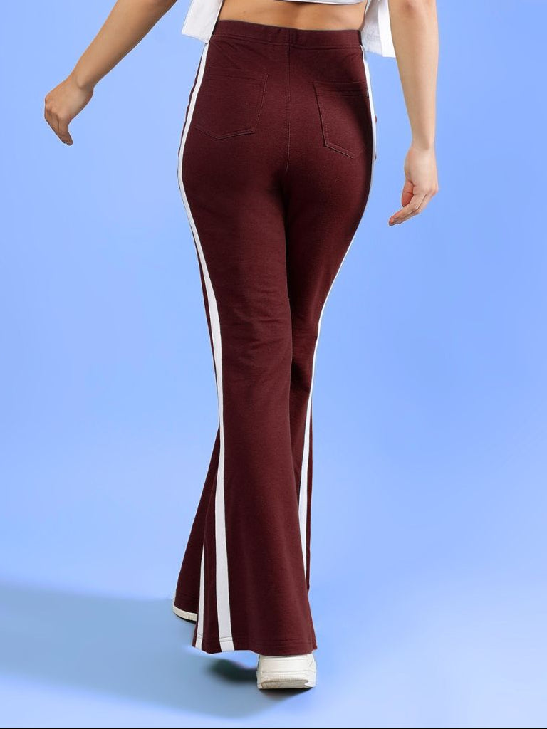 WOMENS FITTONIA COOL WIDE FLARE JOGGERS MAROON with white side stripes, showcasing a relaxed fit and flared silhouette.