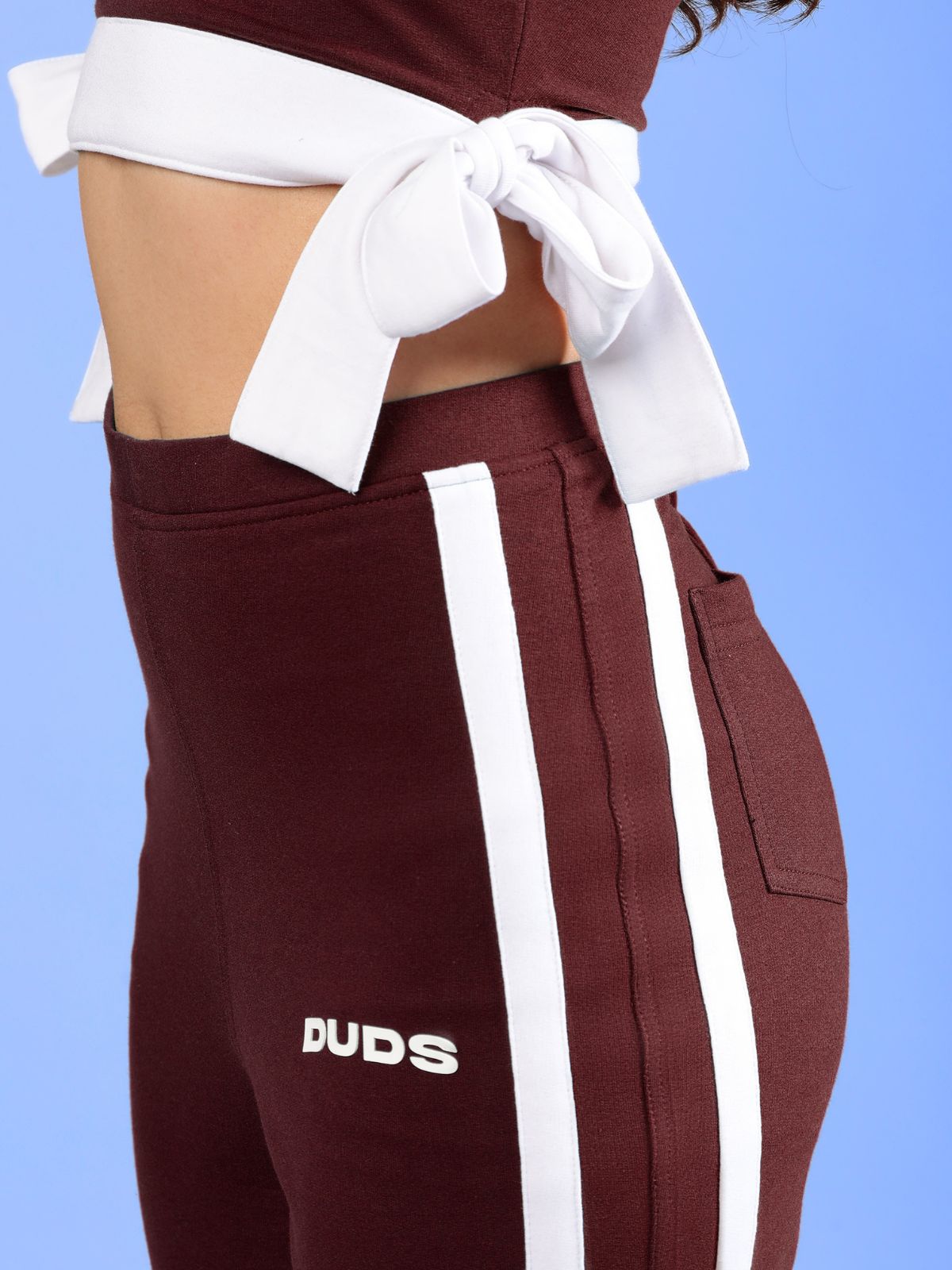 WOMENS FITTONIA COOL WIDE FLARE JOGGERS MAROON with stylish white side stripes and relaxed fit, captured from the side.