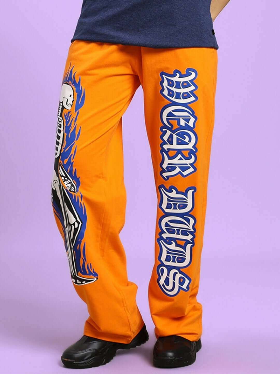Orange women's relaxed fit joggers with flaming skeleton print and bold typography, customizable size option available.