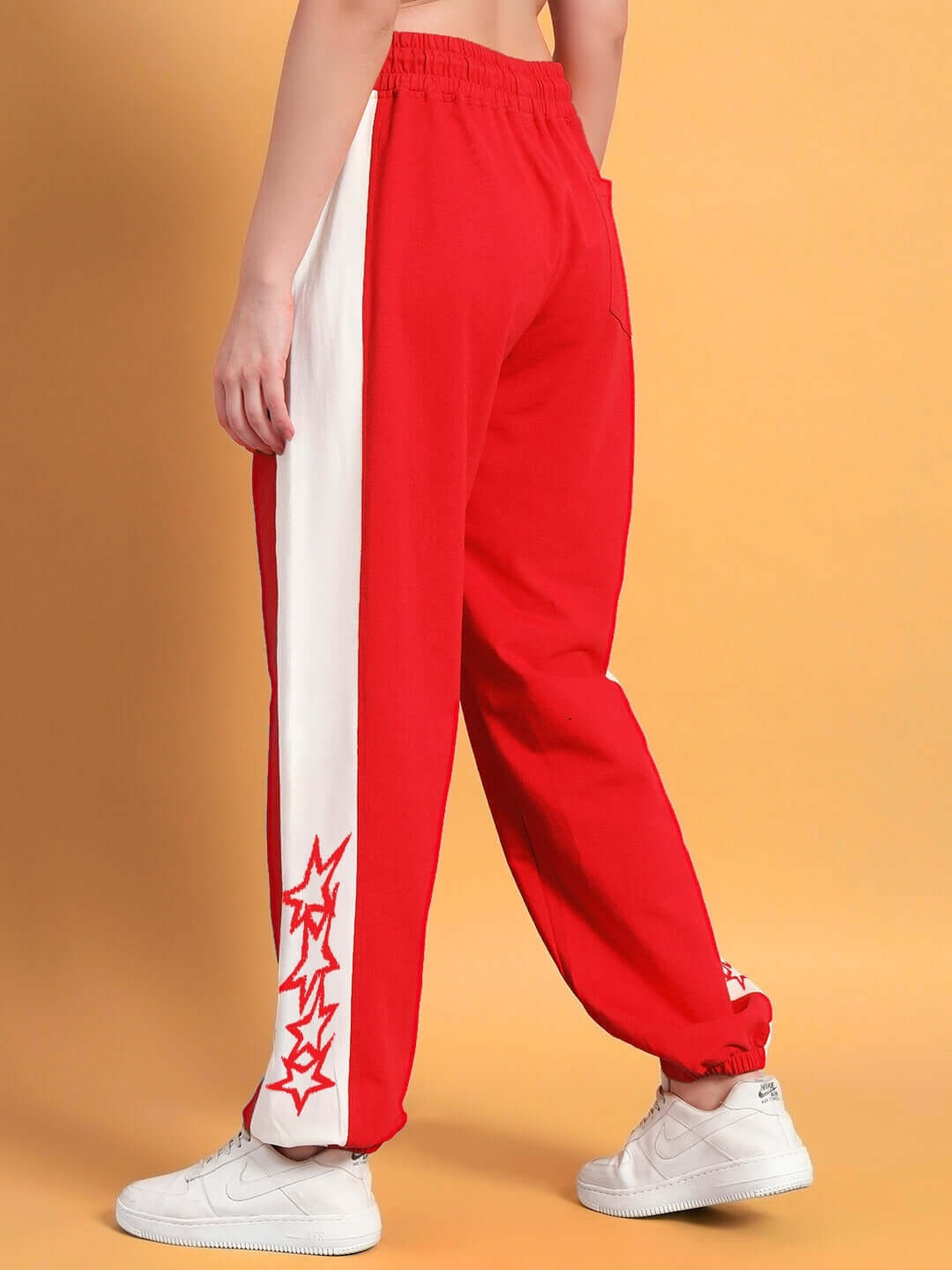 Women's red and white relaxed fit joggers by DUDS, showcasing stylish side stripe and unique design, perfect for comfortable wear.