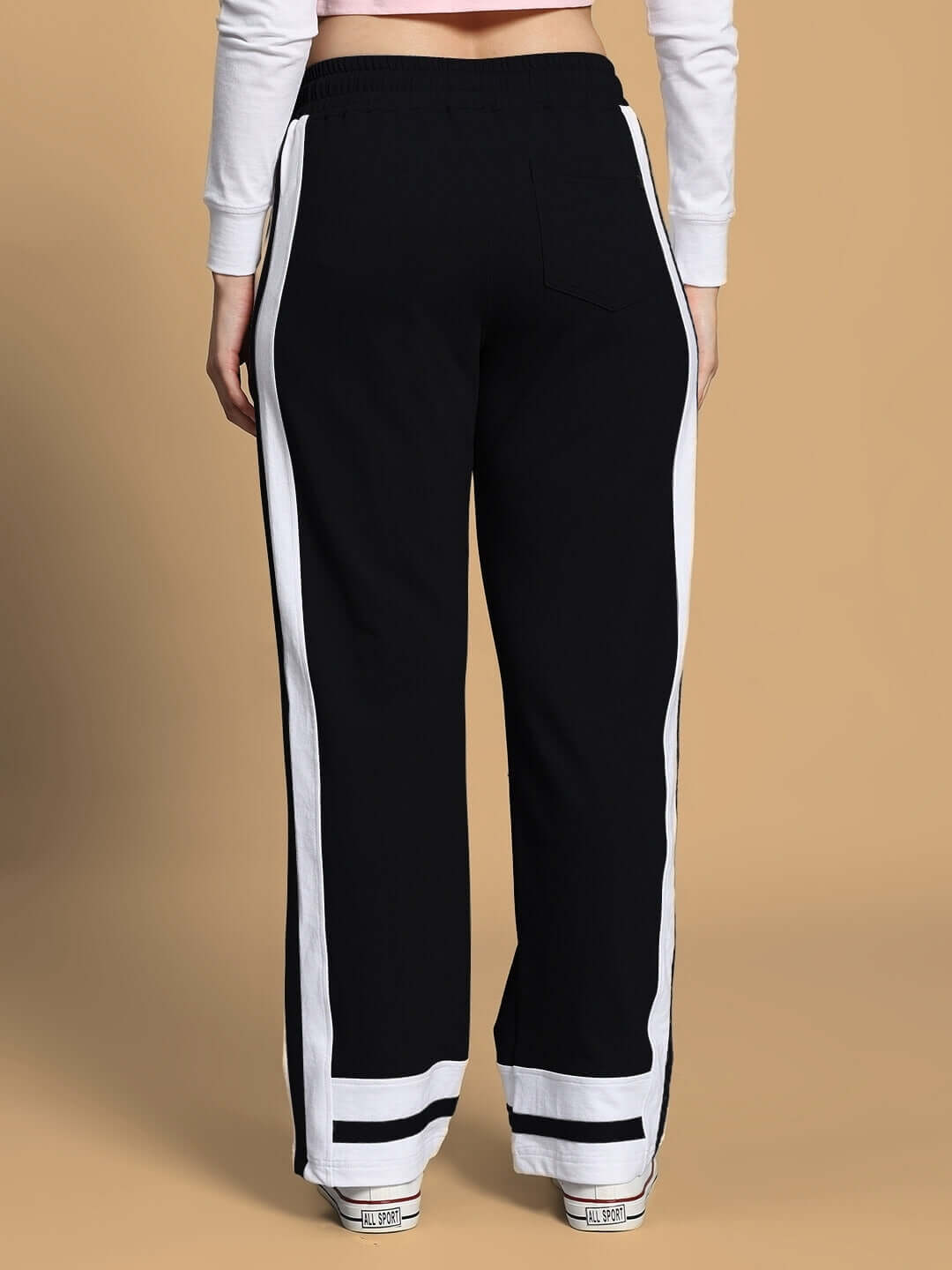 Back view of WOMEN'S FLORA CO-ORD SET PINK BLACK pants, featuring black fabric with white stripes, designed for stylish streetwear.