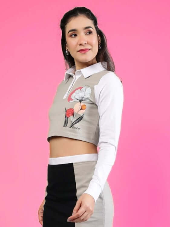 Grey and white women's Flora crop top with regular sleeves, featuring floral embroidery, styled against a pink background.