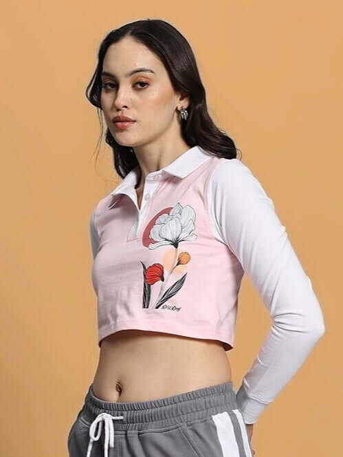 Women's pink and white crop top with floral design, featuring long sleeves and premium cotton fabric, styled against a peach background.
