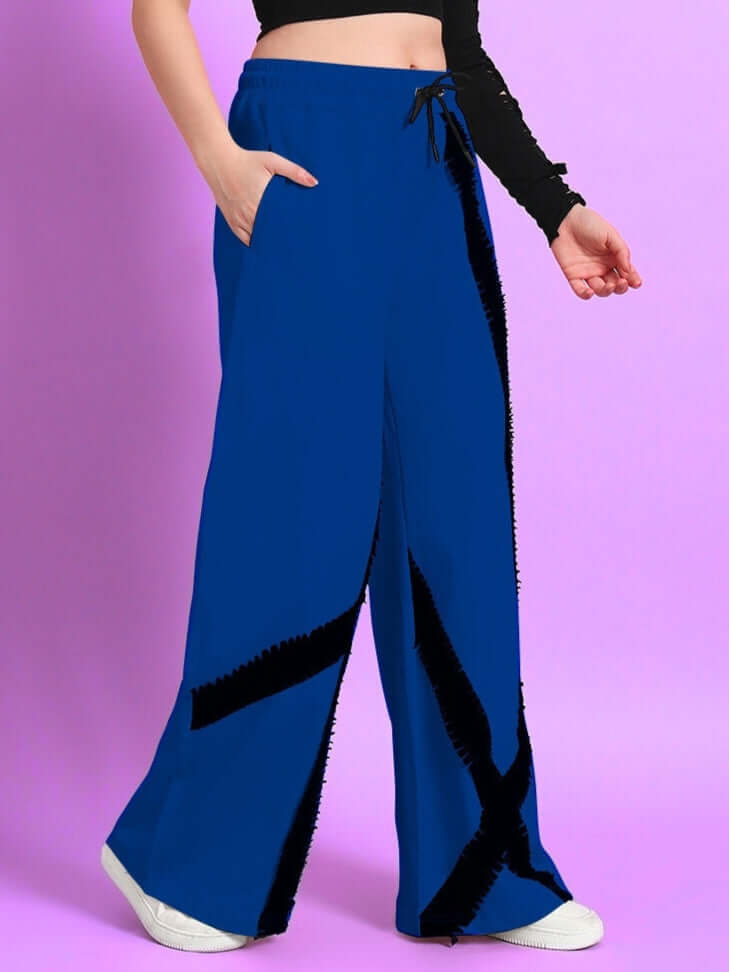 Women's blue jogger with frayed textured stripes, side pocket, and drawstring waist, styled against a pink background.