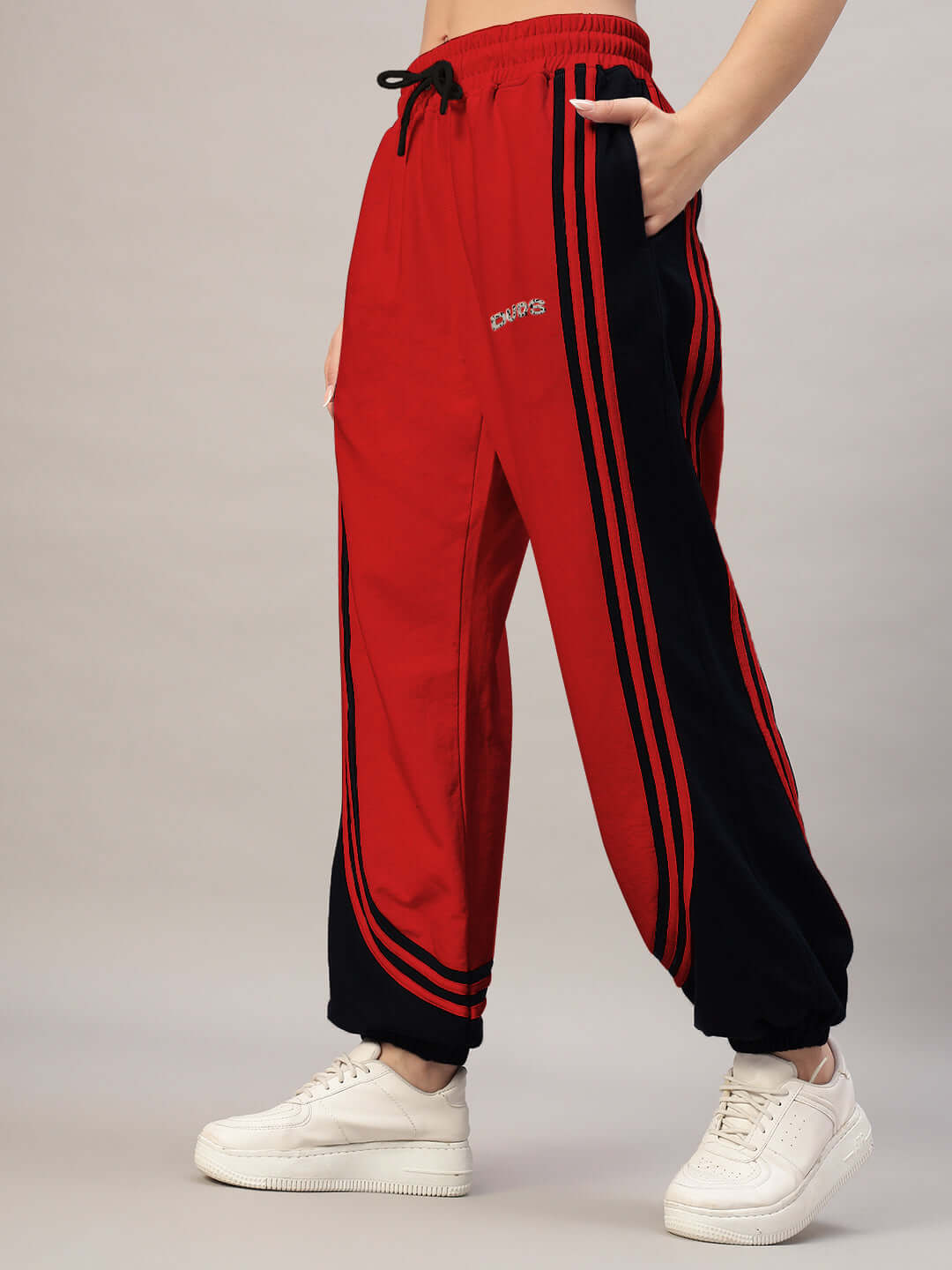 Woman wearing red and black Women's Frenzy Curve Contrast Joggers with sneakers, showcasing comfortable and stylish fit by DUDS.