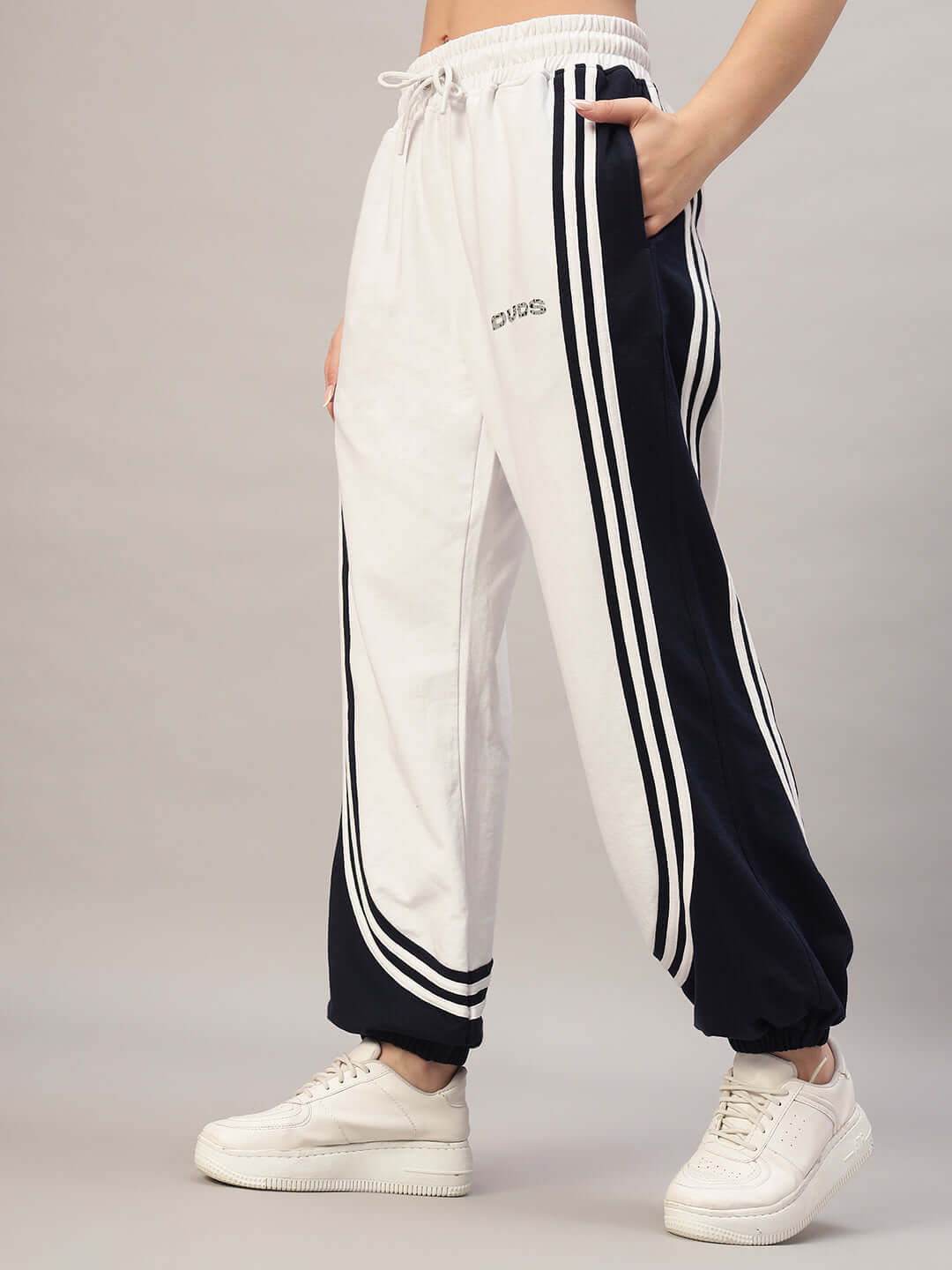 Woman wearing DUDS Women's Frenzy Curve Contrast Joggers in white and navy with stripe design, showcasing comfortable fit and style.