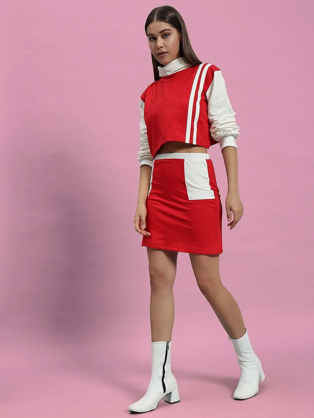 Model wearing WOMEN'S FREYA CO-ORD SET in off white and red, made from premium cotton French terry lycra blend, on a pink background.