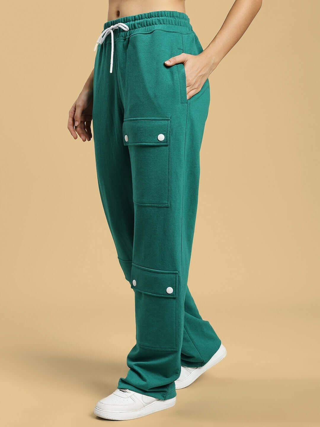 Woman wearing green baggy jogger pants with flap pockets and drawstring waist, made by DUDS.