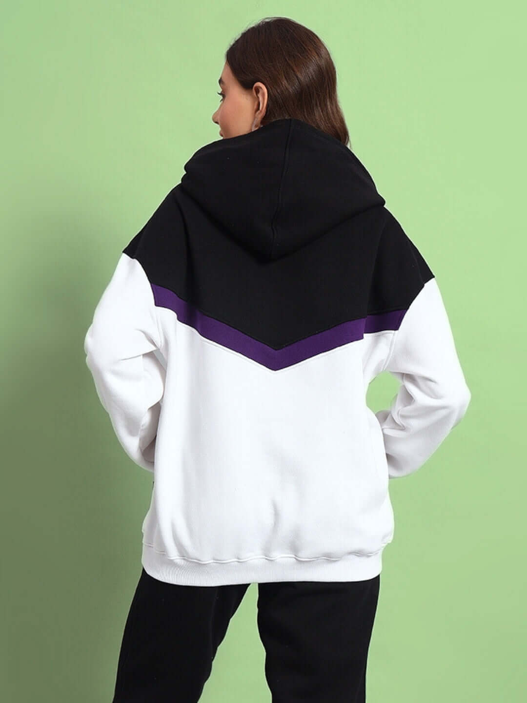 Back view of WOMEN HARLEY FLEECE COLORBLOCK HOODIE WHITE PURPLE with black hood on green background