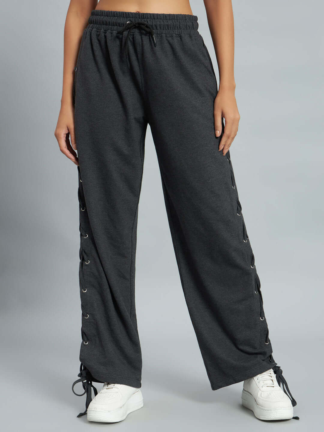 Women's Hazel Relaxed Fit Joggers in Grey with drawstring waist and lace-up sides, worn by a model, paired with white sneakers.