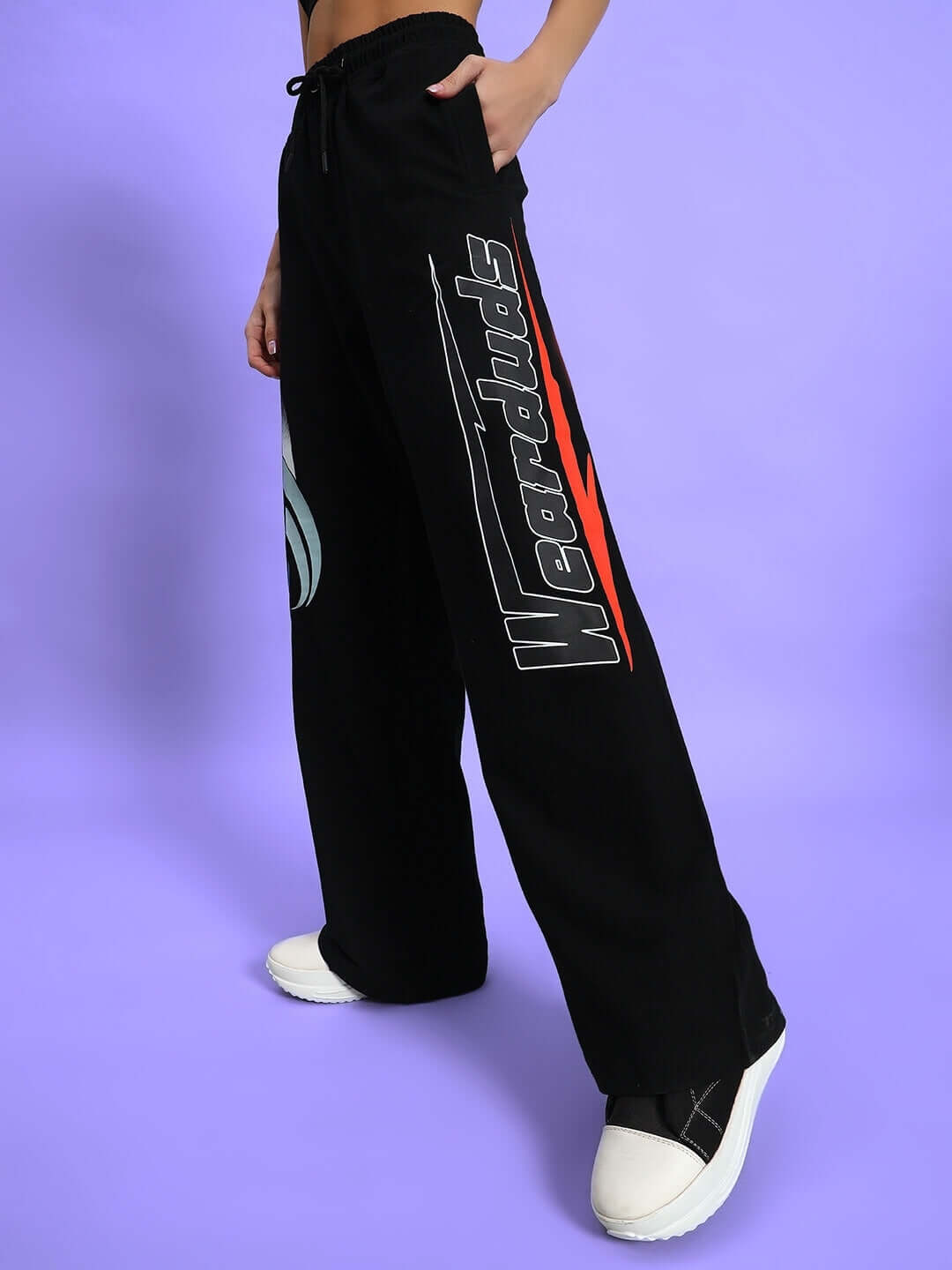 Model wearing black relaxed fit jogger pants with graphic text on side, showcasing comfortable and stylish design.