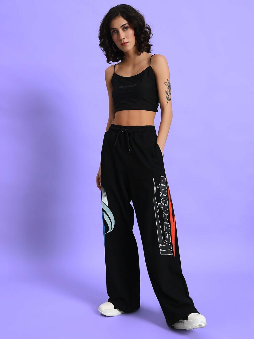 Woman wearing DUDS black relaxed fit joggers with graphic designs, featuring a comfortable fit for casual wear.