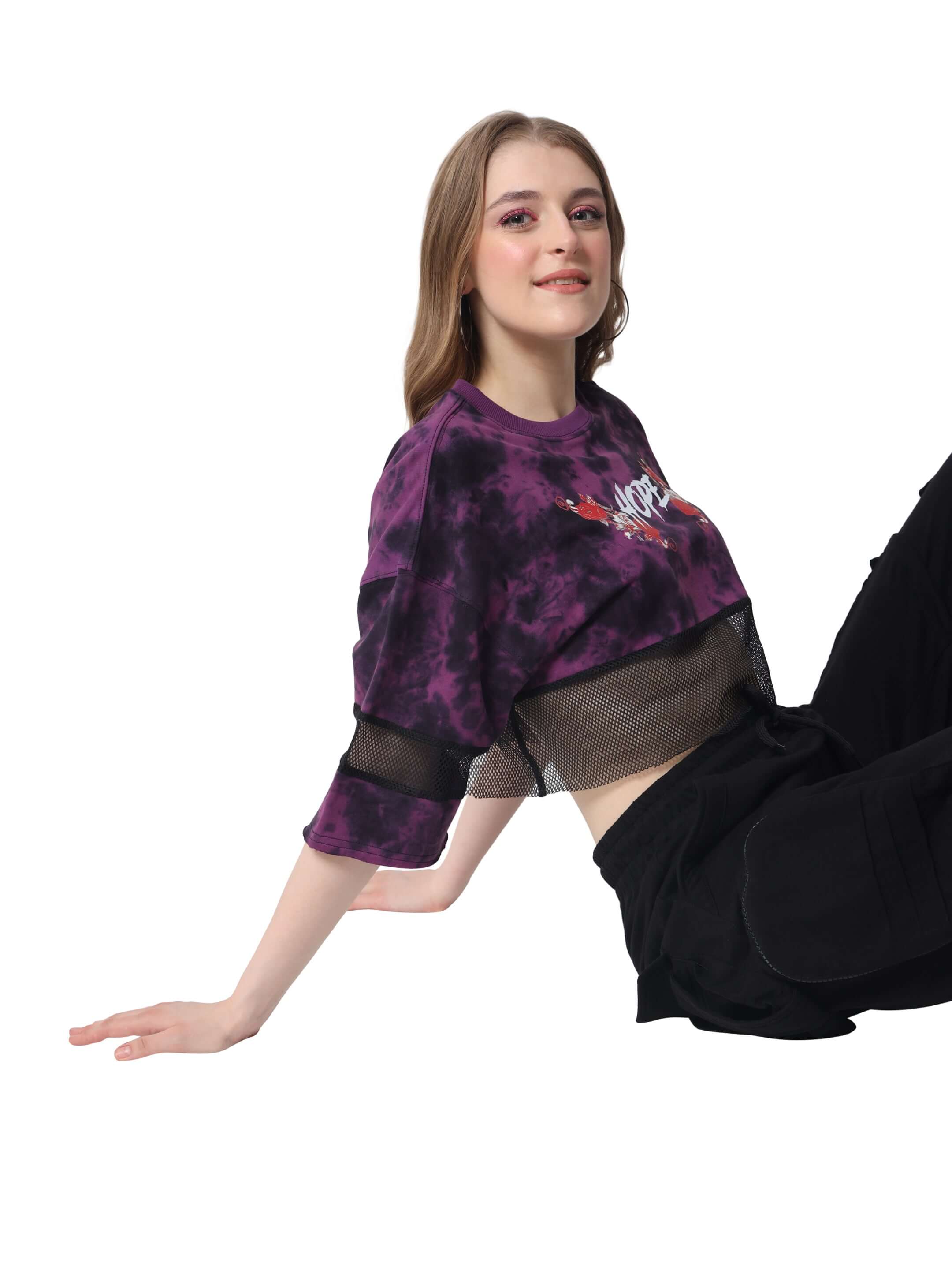 Model wearing women's purple tie dye oversized cropped t-shirt, showcasing a stylish and comfortable design.