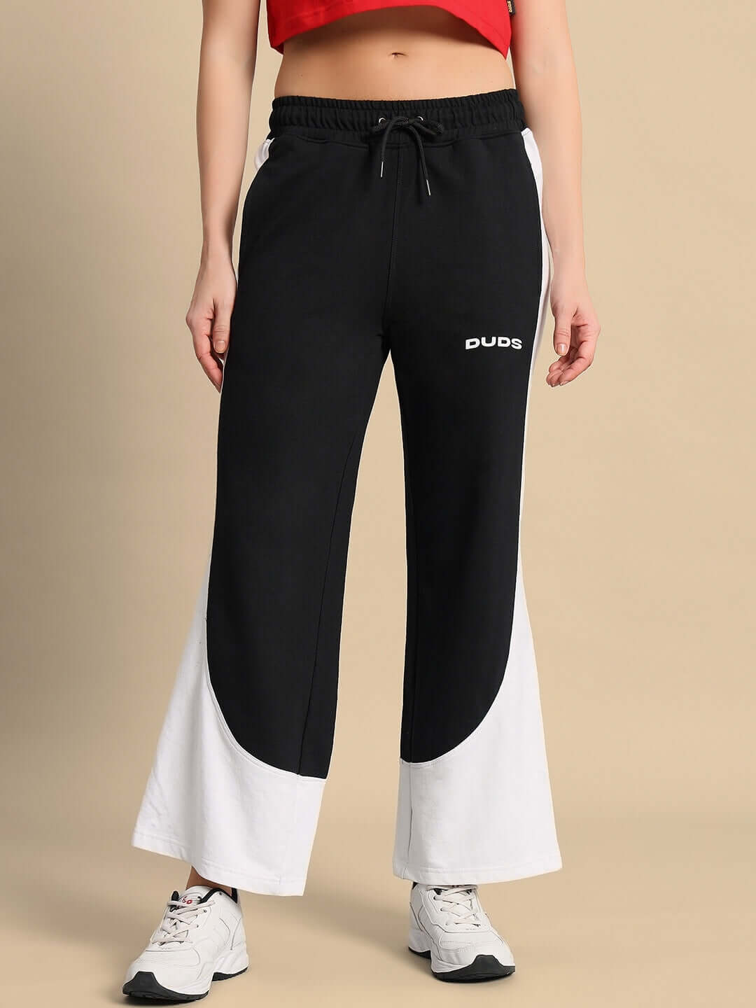 Black-white women's baggy joggers with drawstring, comfortable fit from DUDS, model wearing sports shoes.
