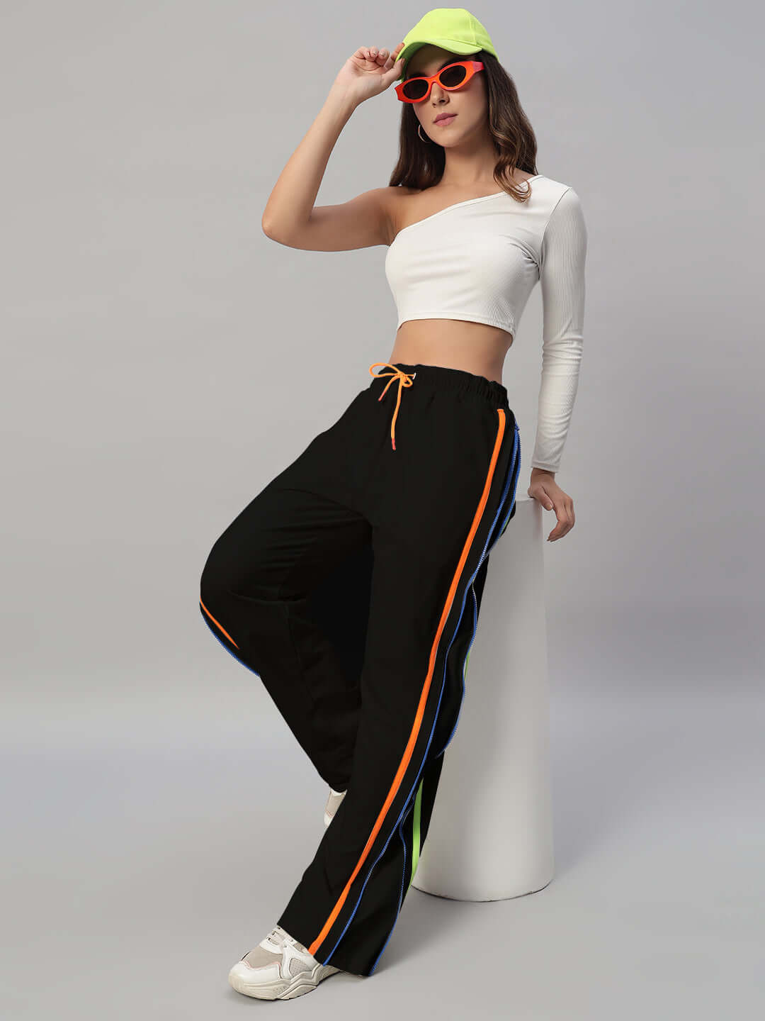 Model wearing WOMEN'S IMPERIAL SIDE ZIPPER JOGGERS BLACK, showcasing stylish design and comfort with vibrant side stripes.