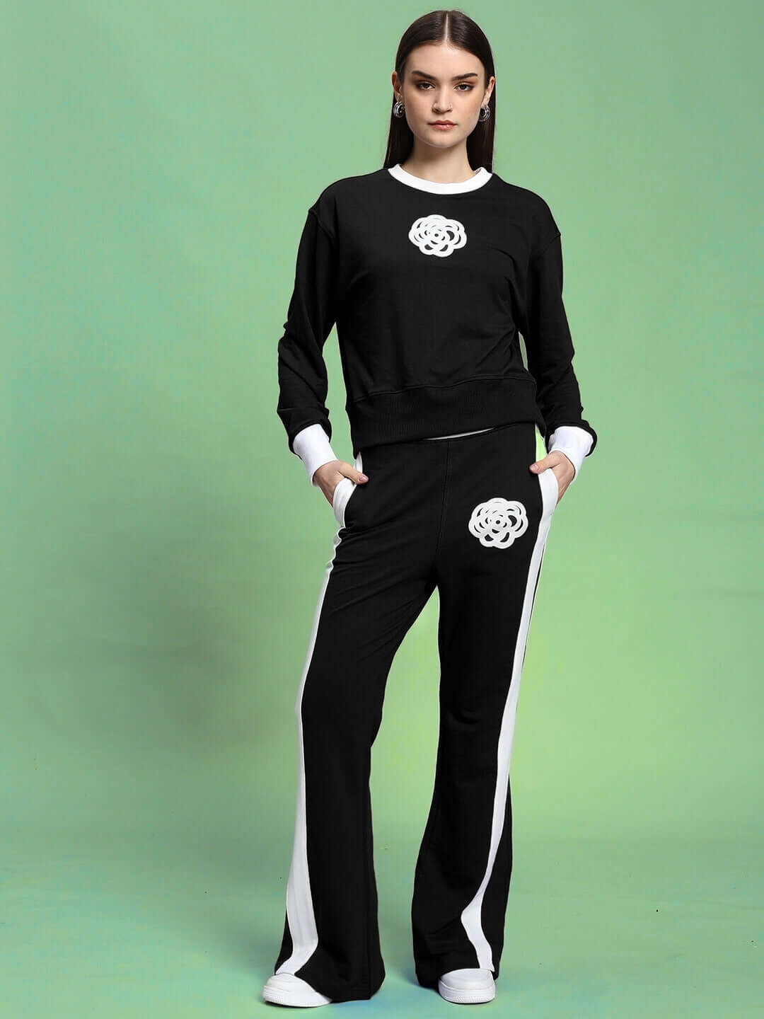 Woman wearing WOMEN'S JESSFLICK RELAXED FIT CO-ORD SET BLACK, featuring sleek design and comfortable fit against a green background.