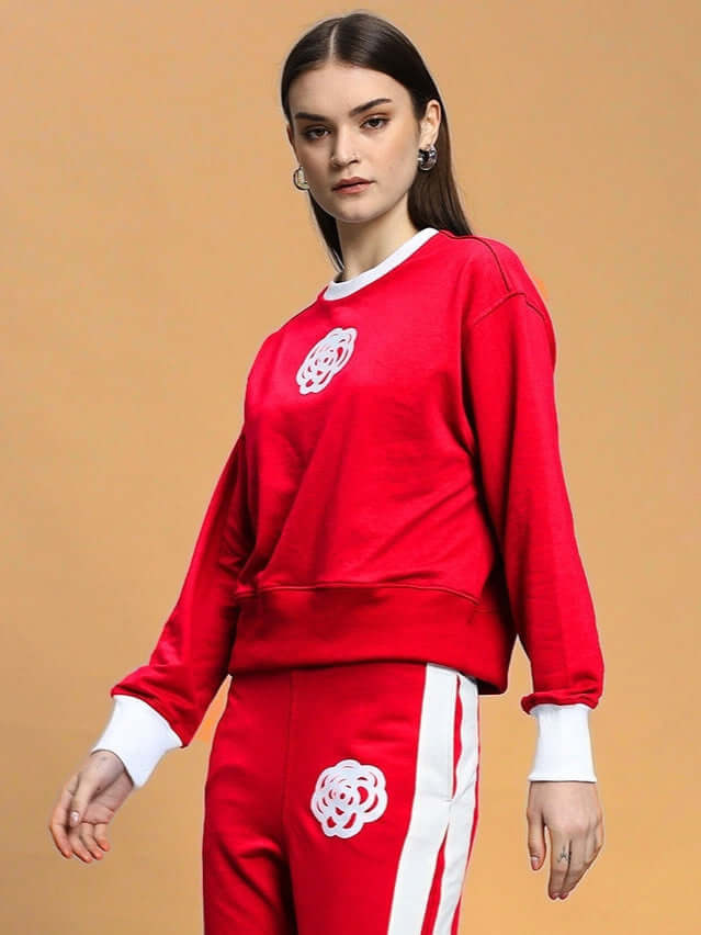 Woman wearing red Women's JessFlick Relaxed Fit Sweatshirt with white cuffs and floral design, made from premium cotton French terry.