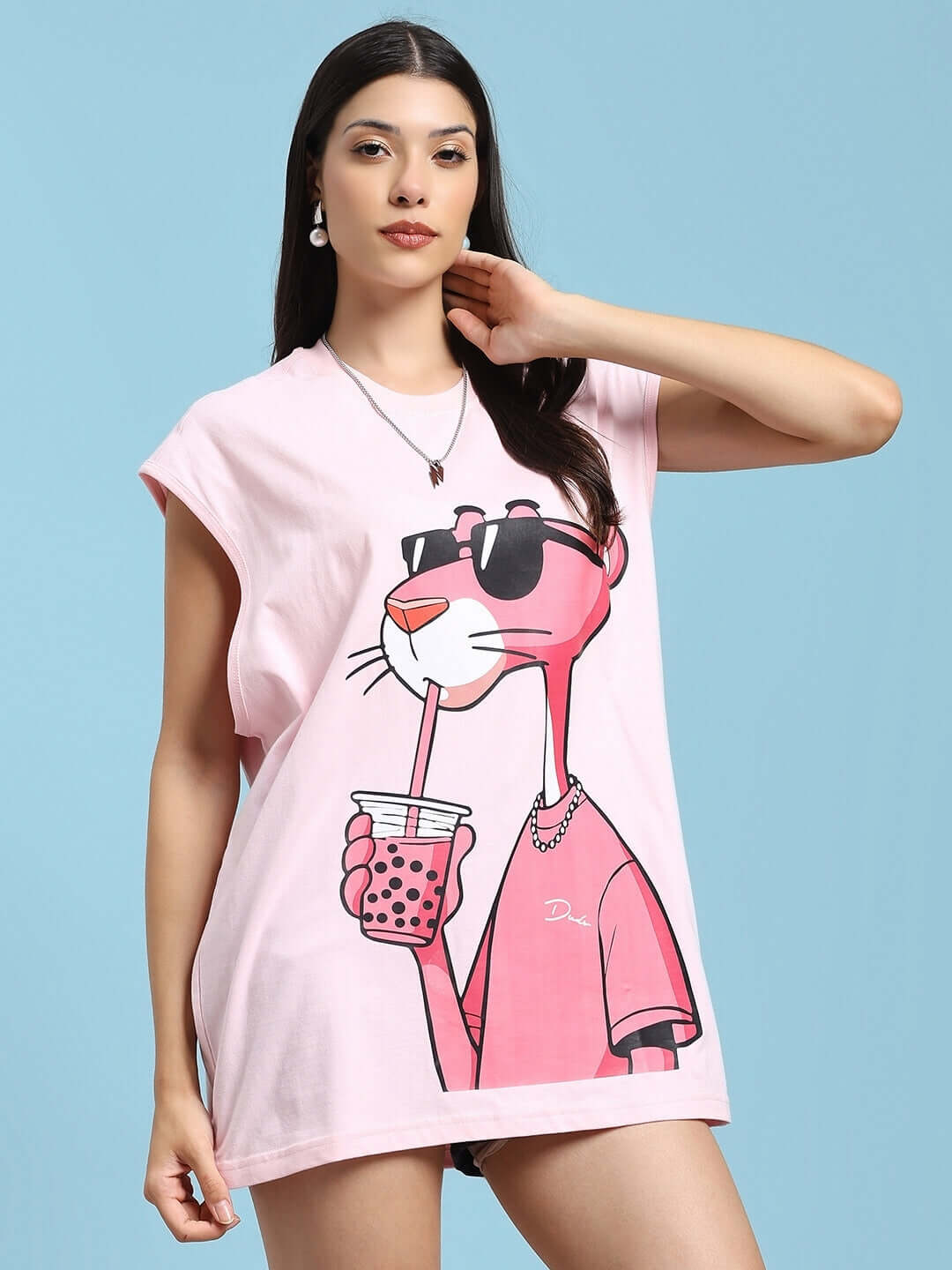 Woman wearing the WOMEN'S JUST CHILL Pink Panther printed T-shirt in pink, featuring a large panther graphic holding a drink.