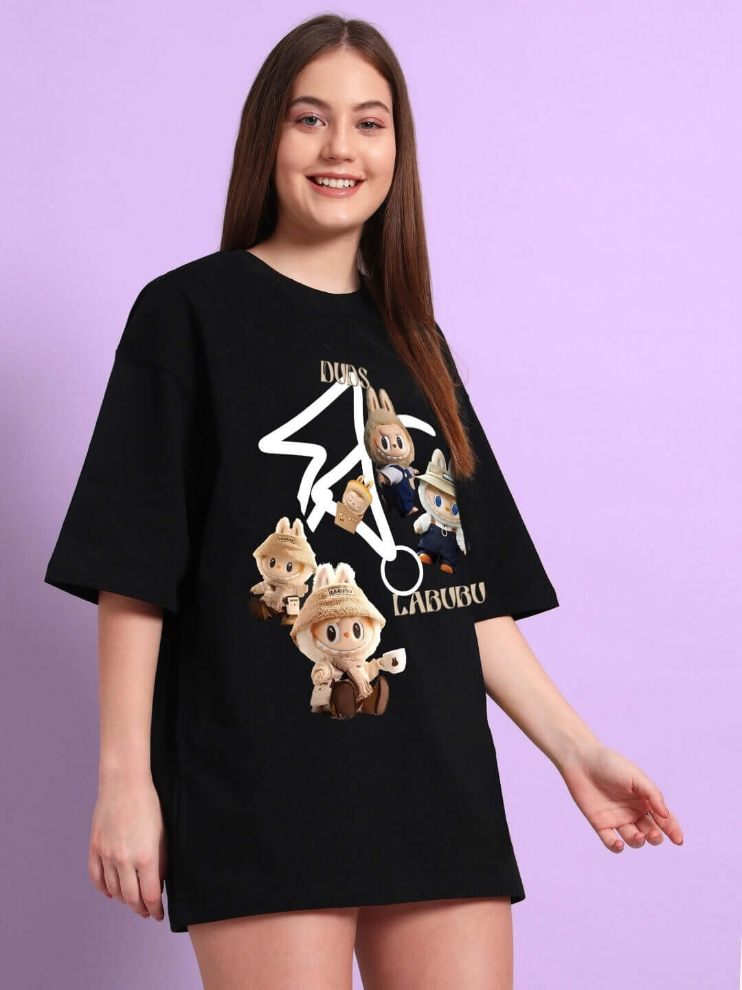 Woman wearing a black oversized T-shirt with Labubu gang print, made of premium cotton blend, standing against a pastel background.