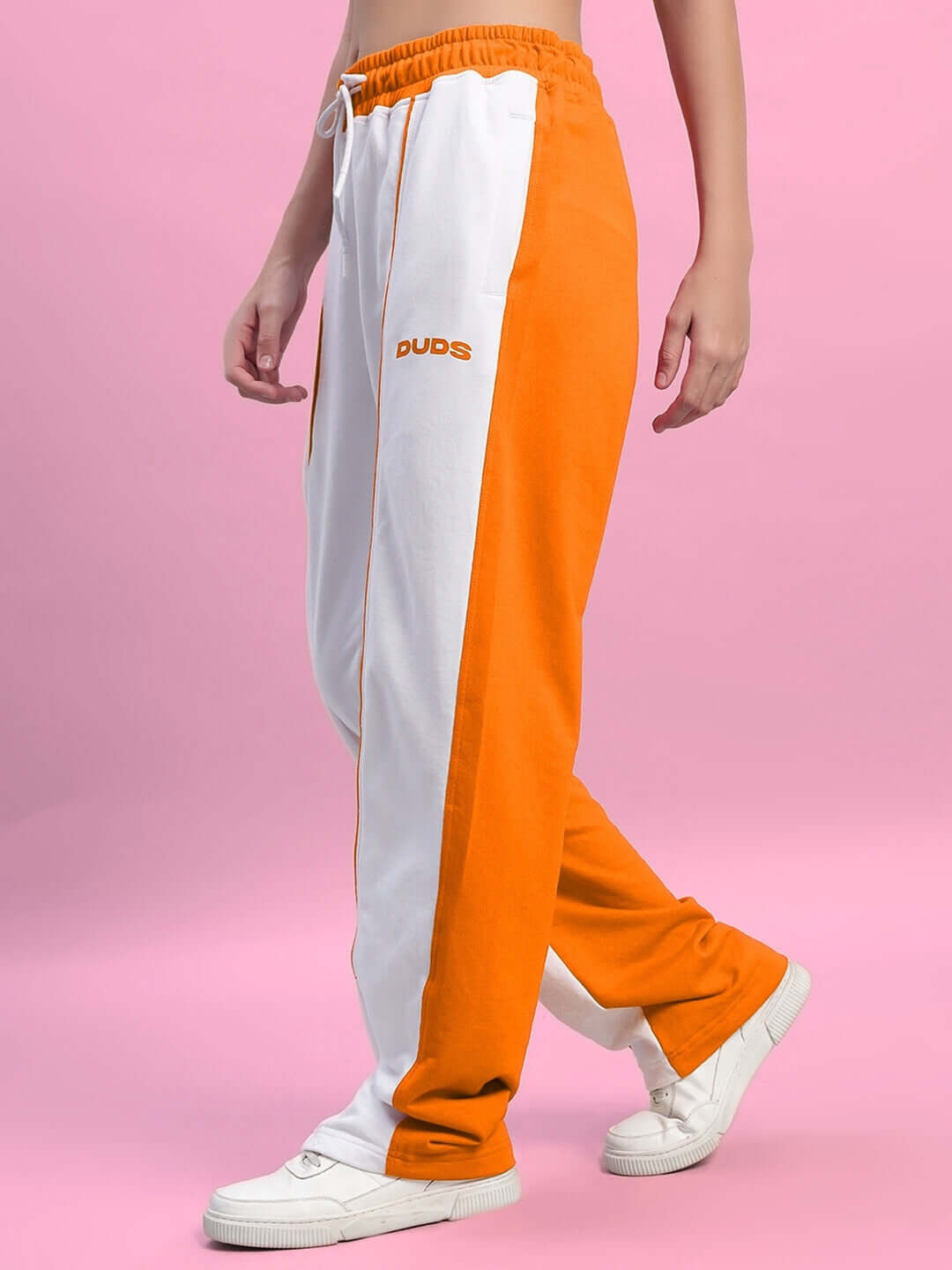 Women's Lagoon Relaxed Fit Joggers in white and orange by DUDS, made-to-order fashion with custom size options, shown on pink background.
