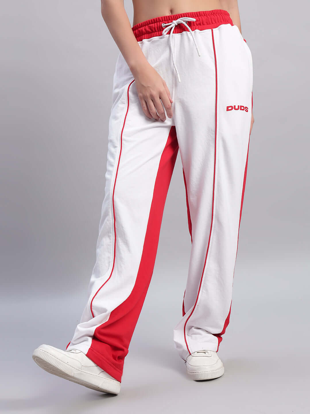 Model wearing women's white and red relaxed fit joggers by DUDS, showcasing sporty style and comfort.