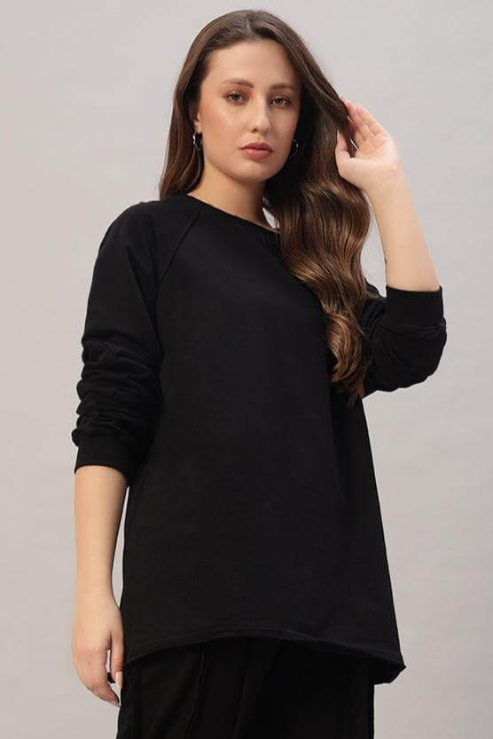 Woman wearing oversized black Lamina sweatshirt, made of premium heavy gauge fabric, showcasing casual streetwear fashion.