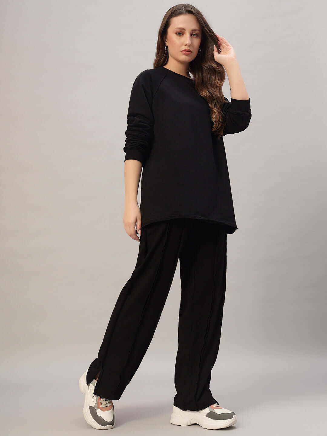 Model wearing Women's Lamina Oversized Co-ord Set in black, featuring relaxed fit joggers and a casual top made from 100% cotton.