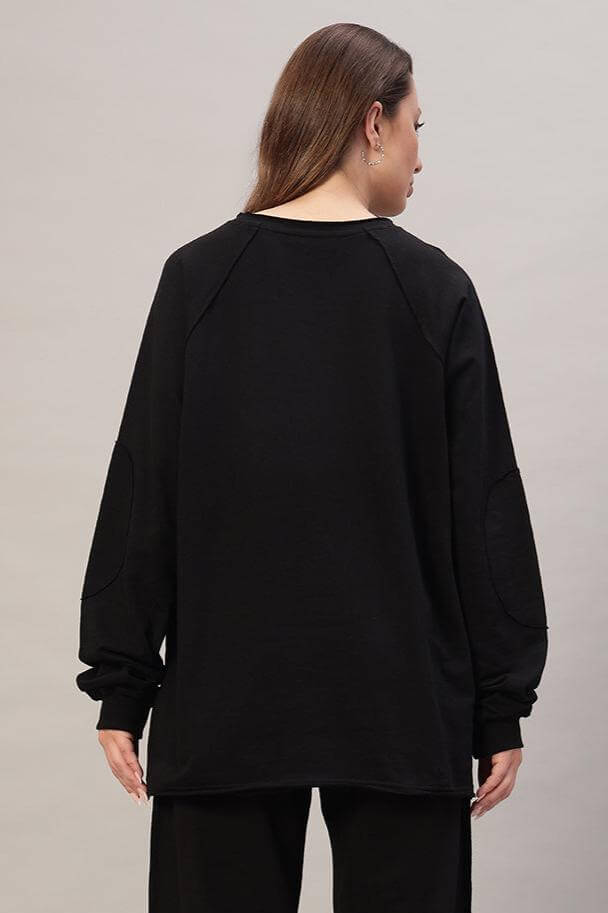 Back view of WOMEN LAMINA OVERSIZED SWEATSHIRT BLACK worn by a model, showcasing the relaxed silhouette and soft fleece design.