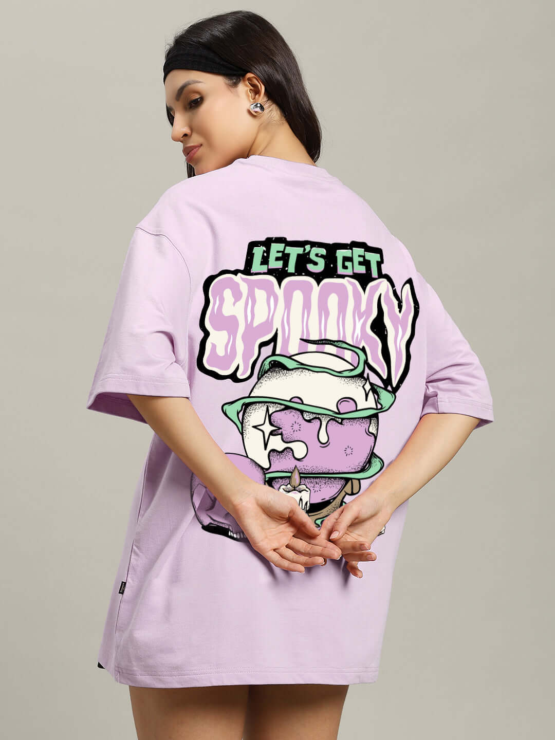 Lavender oversized t-shirt with 'Let's Get Spooky' print, worn by a woman, featuring graphic design on the back.