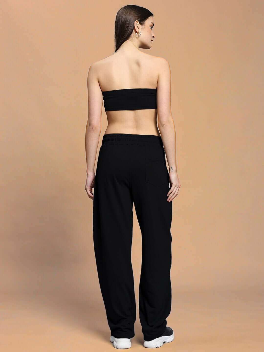 Rear view of woman wearing black Women's Lia Co-Ord Set, showcasing relaxed fit joggers with elastic waistband and drawstring.