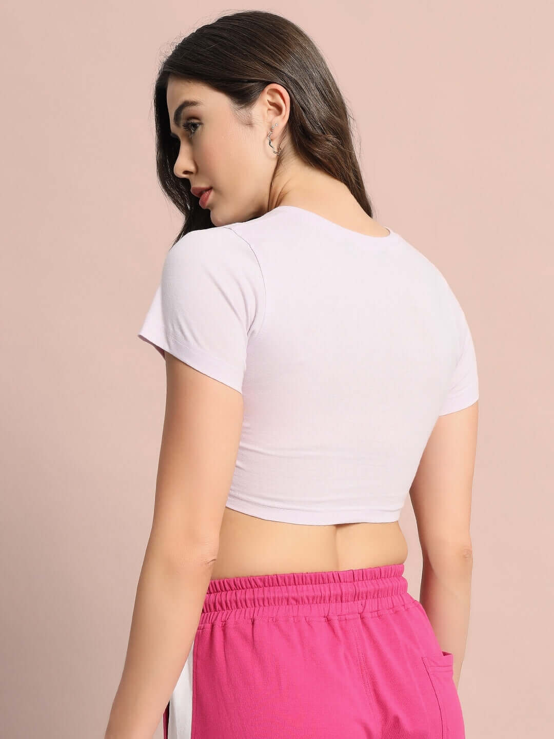 Back view of woman wearing lilac women's crop top, made from premium cotton rib fabric, paired with pink bottoms, against a neutral background.