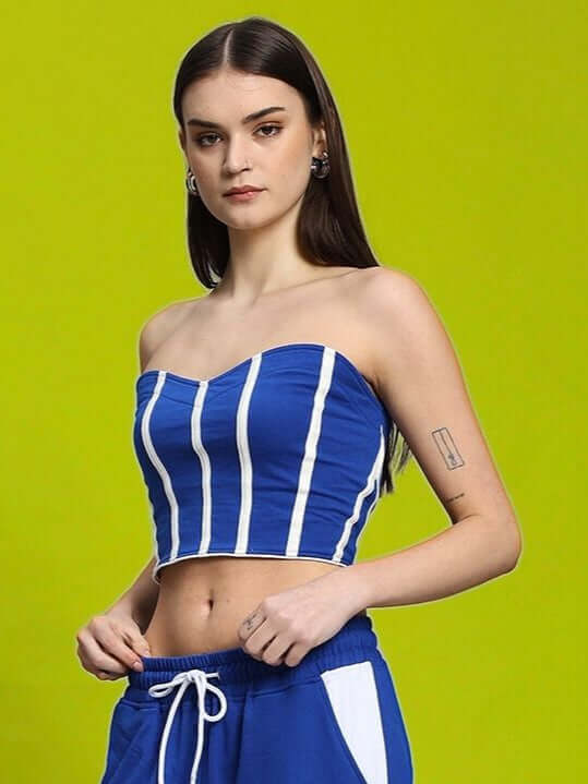 Model wearing WOMEN'S LIVIANA COOL BANDEAU TOP BLUE-WHITE with a bright green background.