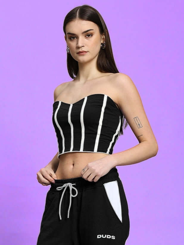 Model wearing black Liviana cool bandeau top with vertical stripes, crafted from premium 100% cotton fabric on a purple background.