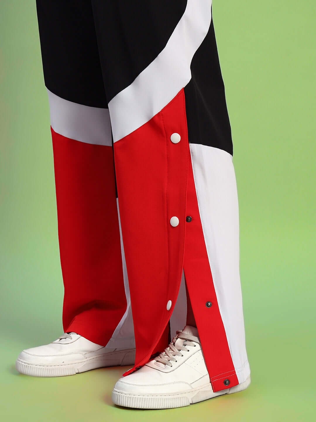 Black and red women's relaxed fit cargo pants with white sneakers on green background. Customize size for perfect fit.