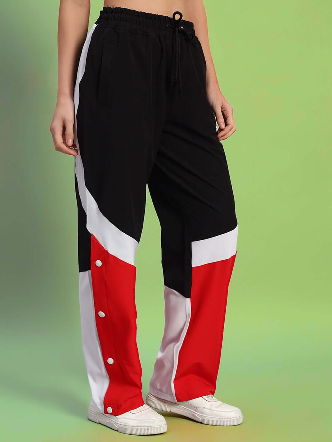 Women's black and red relaxed fit cargo pants with white accents, shown on a green background.