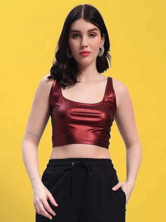 Woman wearing maroon metallic crop top by Color By Colours on yellow background; stylish and modern women's fashion top.