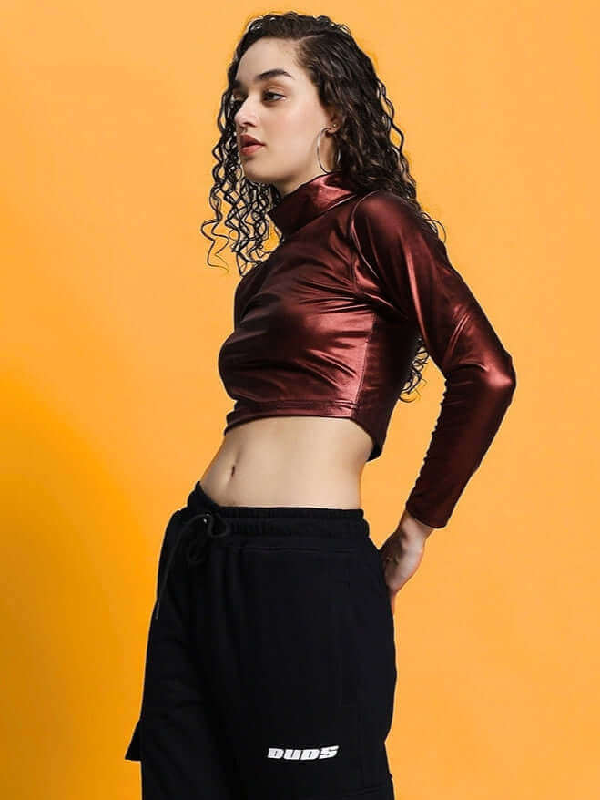 Maroon metallic women's crop top by Color By Colours, styled with black pants on a yellow background.