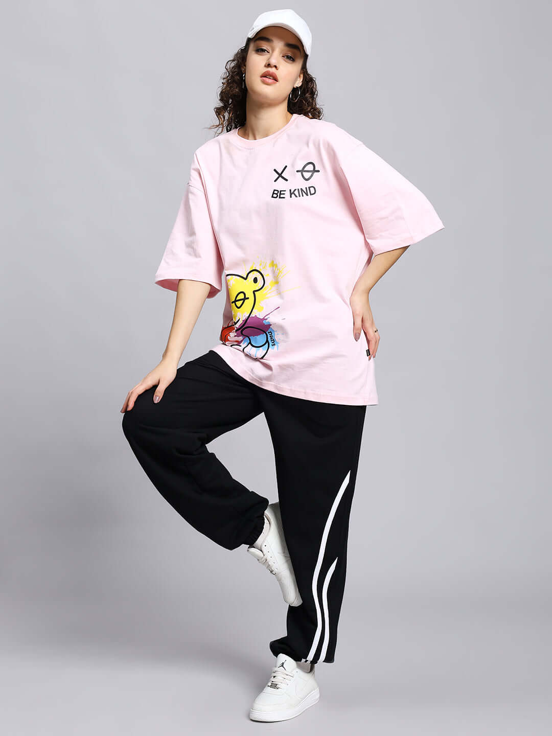 Model wearing black Women's Megastar 2 Stripe Jogger with white stripes, paired with a pink t-shirt and white sneakers.
