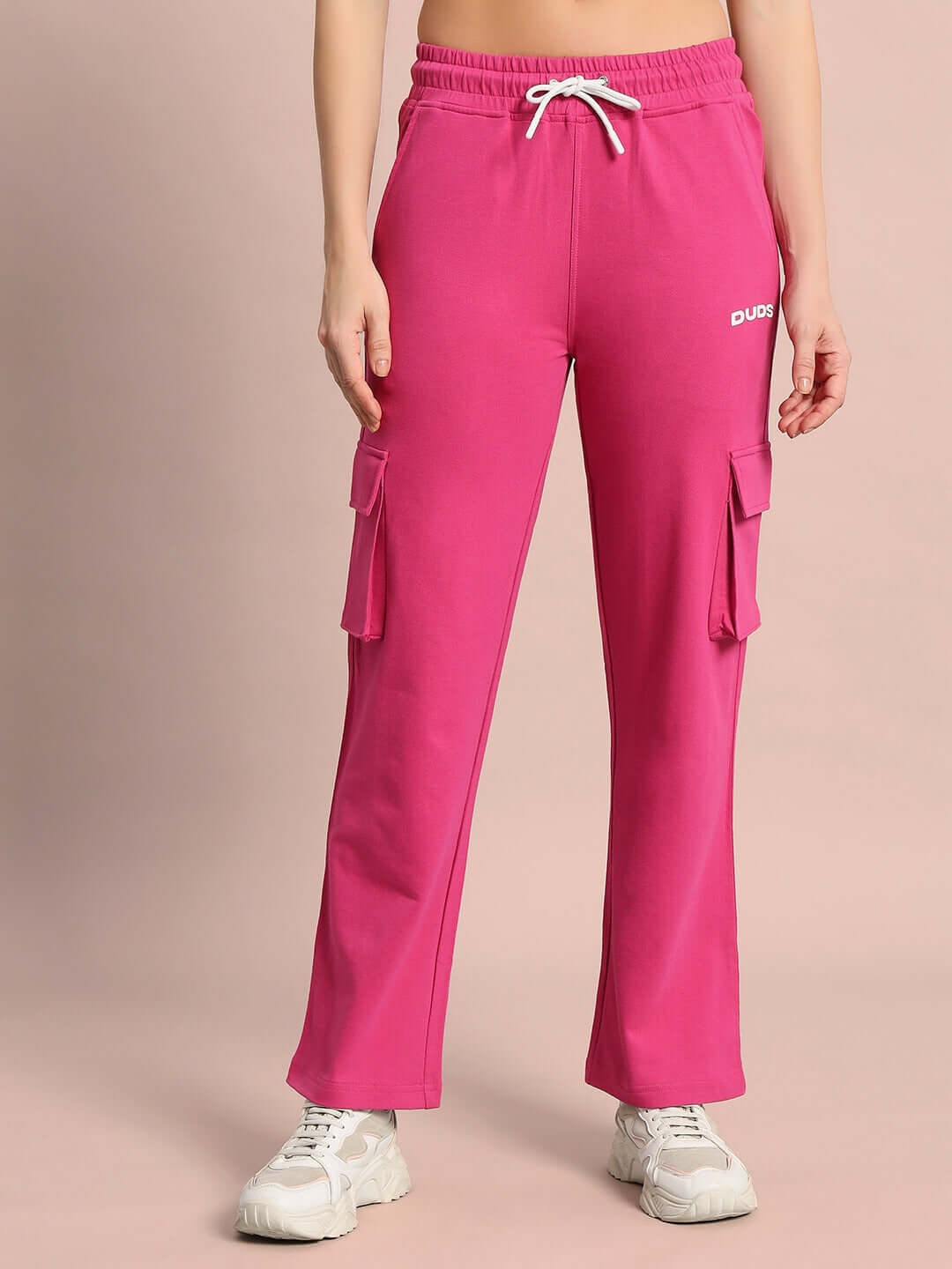 Women's Merriam Joggers in pink with pocket detail, made by DUDS, shown worn with white sneakers.