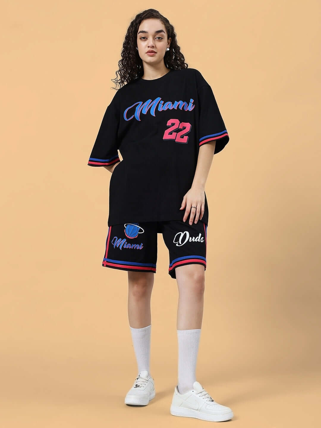 Model wearing WOMEN'S MIAMI COLORBLOCK CO-ORD SET BLACK with vibrant prints, showcasing stylish sportswear.