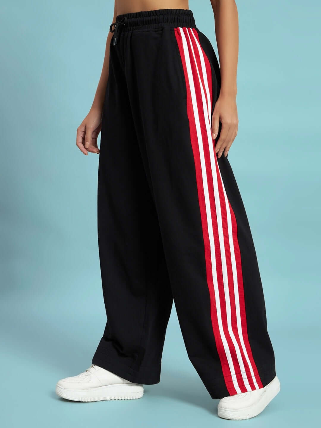 WOMEN'S MILANO RELAXED-FIT JOGGERS BLACK-RED Model wearing black joggers with red stripes, showcasing relaxed fit and stylish design.